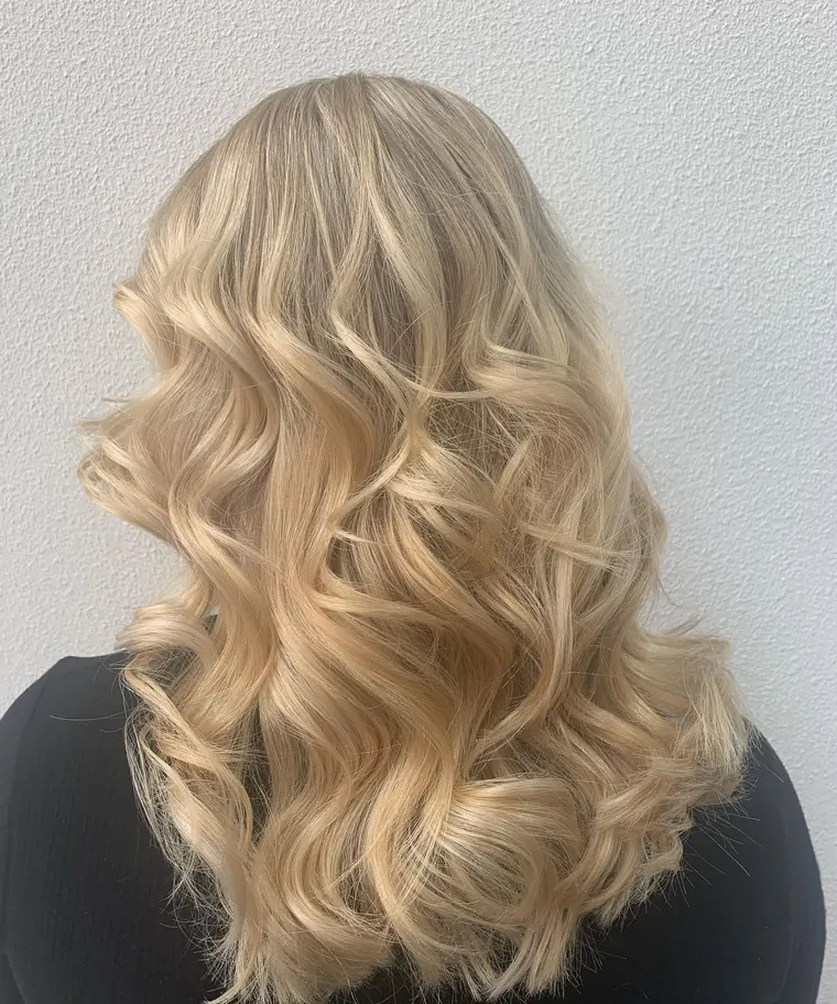 Lang blond dameskapsel met krullen